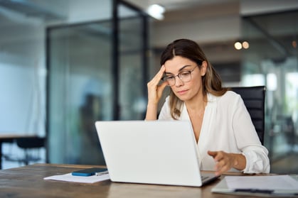 woman thinking about retail demand planning and forecasting at desk