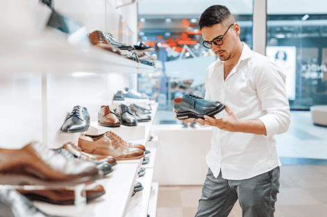 Shopper reviewing athletic shoes, highlighting AI-based demand forecasting and accurate prediction of future demand.