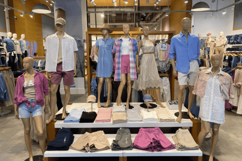 Clothing display with mannequins showing inventory planning and seasonal assortment.