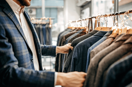  A man examining suits in a retail store, highlighting the real-world results of mutually beneficial retail partnerships that improve product assortment and customer experience.