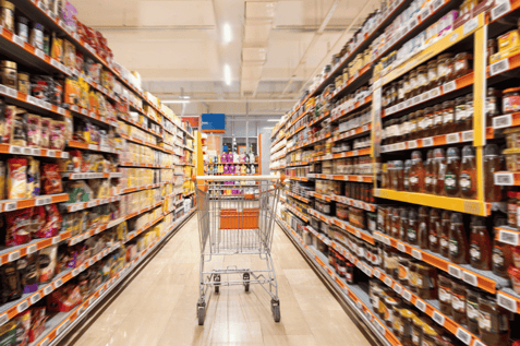 Grocery aisle with shopping cart, showing how invent.ai’s AI platform supports real-time inventory and replenishment.
