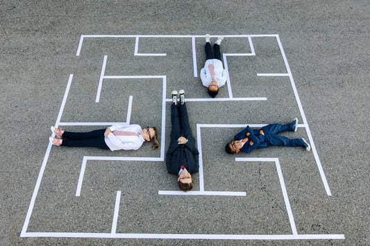 Lying in a maze, metaphorically illustrating the complexity of financial modeling and how retail financial forecasting software helps navigate market conditions and budgeting challenges.