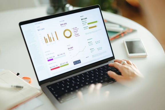 Close-up of a dashboard on a laptop showing key sales and revenue metrics, representing the use of AI-driven merchandise planning software for demand forecasting, performance tracking, and strategic planning.