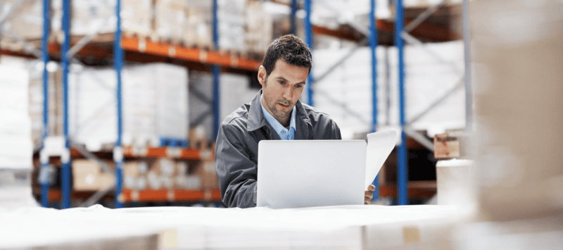 Man on laptop in warehouse