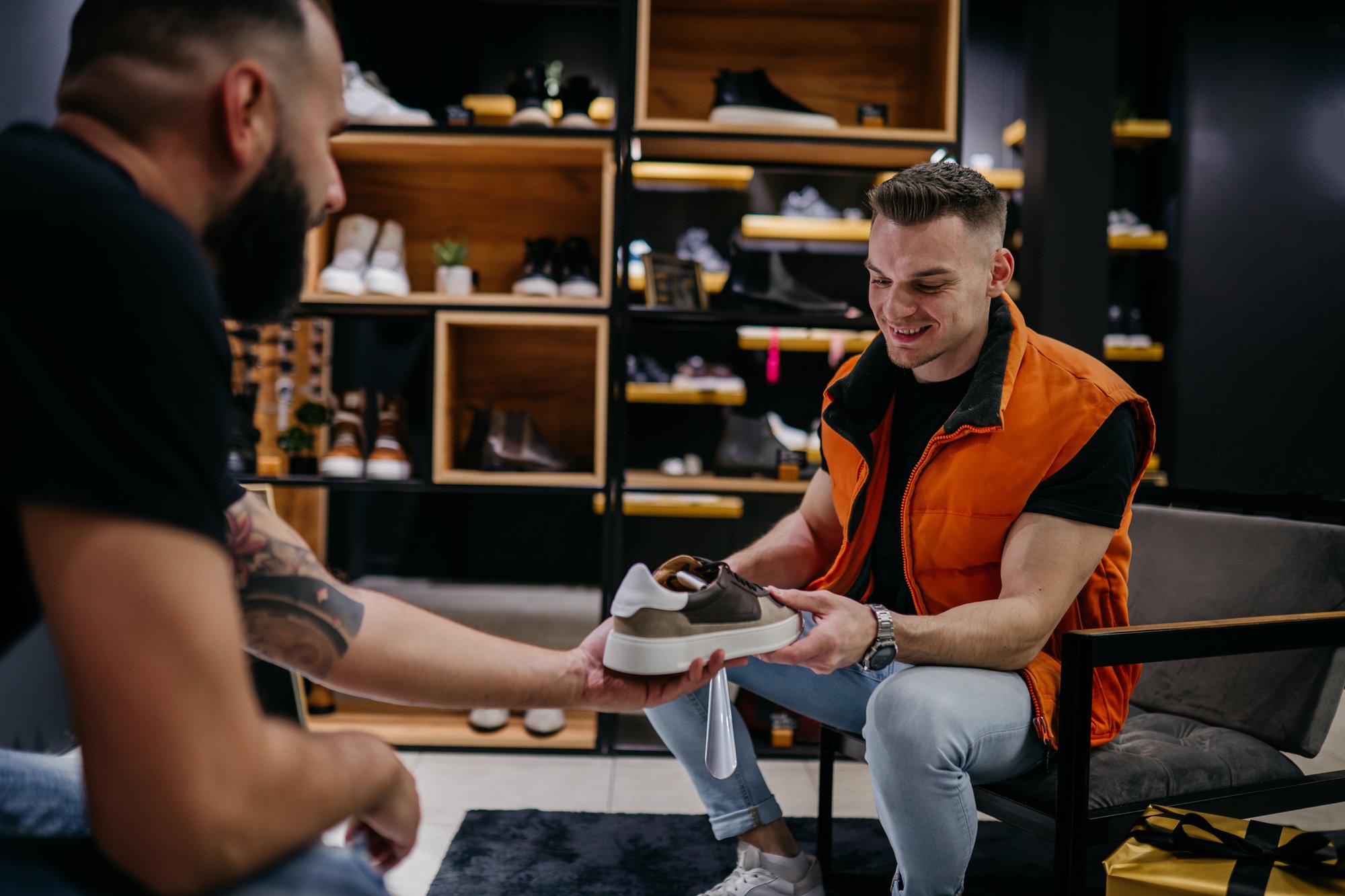 Salesman helping shopper with sneakers