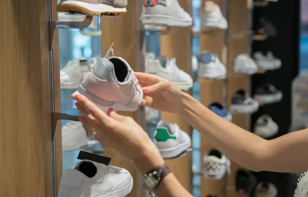 Customer choosing sneakers in Footasylum store, symbolizing AI-powered inventory planning and replenishment