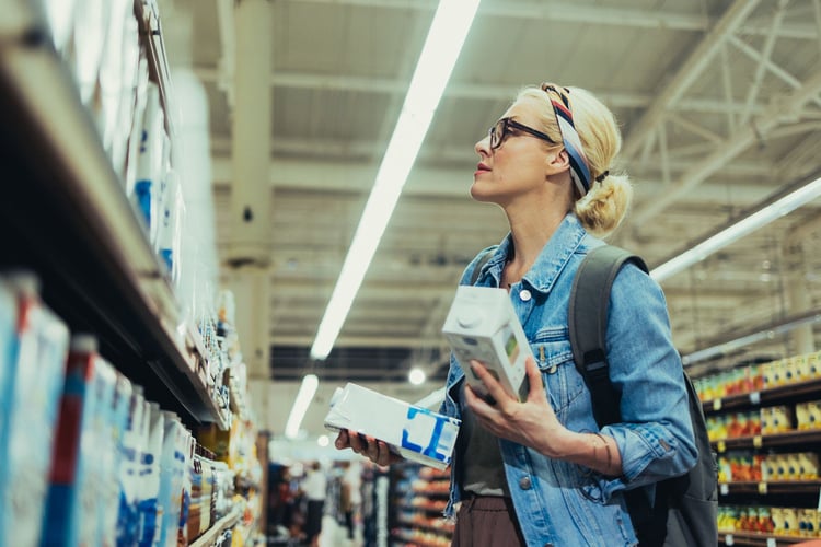 Woman comparing prices in grocery store
