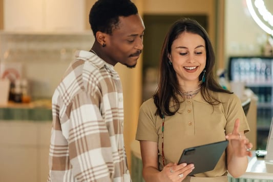 Retail planning specialists reviewing inventory optimization and business strategy using a digital tablet in a store.