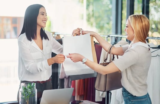 Retail associate providing service while inventory optimization software updates safety stock levels in real-time.