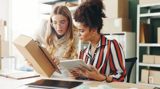 Retail buying team using a tablet to manage supplier negotiation, vendor management and logistics planning.