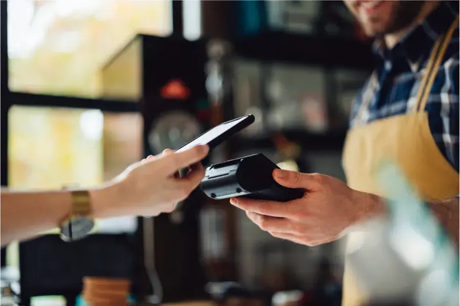 Customer making a mobile payment at checkout, symbolizing how agentic AI architecture enables decision-making, collaboration, and workflow optimization in retail.
