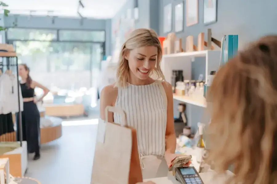 Retail cashier supporting customer transactions and enhancing customer experience in a shop.