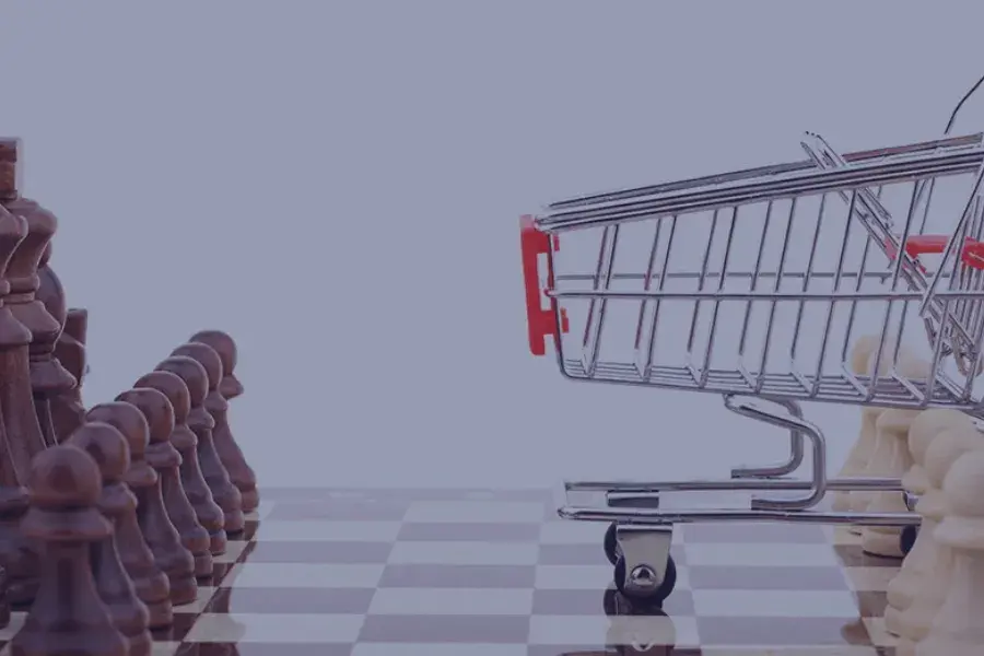 A chessboard with a miniature shopping cart in the middle, symbolizing an omnichannel retail strategy that seamlessly integrates mobile apps, physical stores, and online shopping to enhance customer journey and satisfaction across all channels.