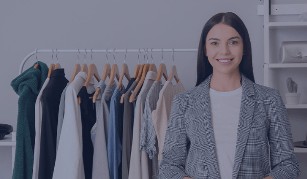 woman standing in front of an assortment of clothes in a retail store and valuing retail demand forecasting