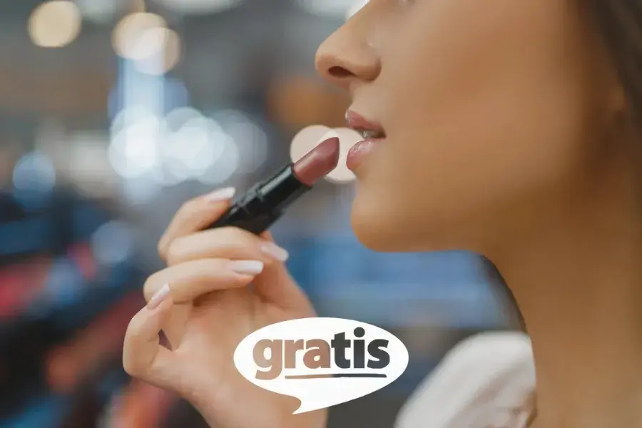 Female shopper applying lipstick in Gratis store that is optimized using inventory optimization software for efficient product availability