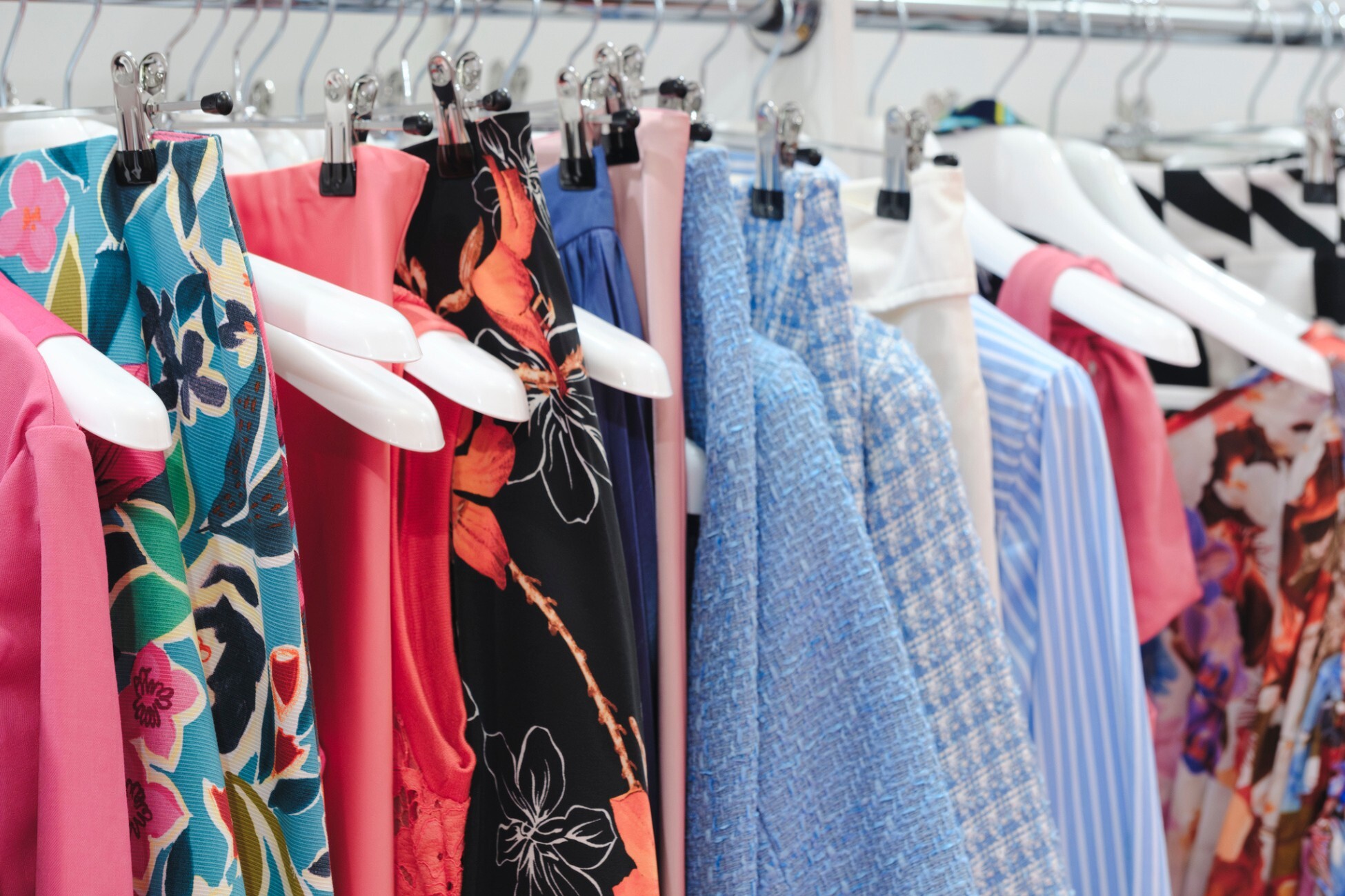 lose-up of colorful patterned dresses on hangers in a retail store, representing inventory levels and the importance of days of inventory in managing stock and optimizing cash flow.