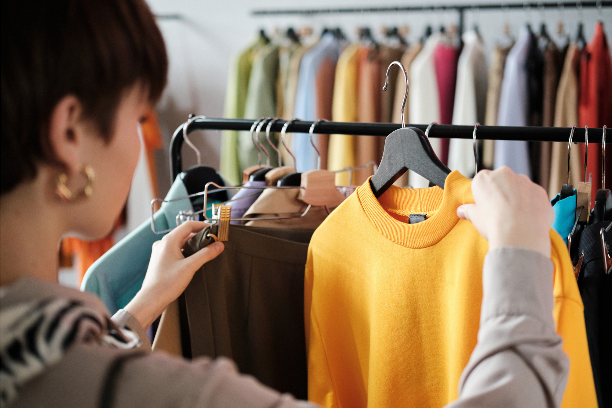 "Shopper browsing clothing rack, representing how merchandise financial planning software and AI-driven retail analytics support demand forecasting, inventory optimization, and margin planning.