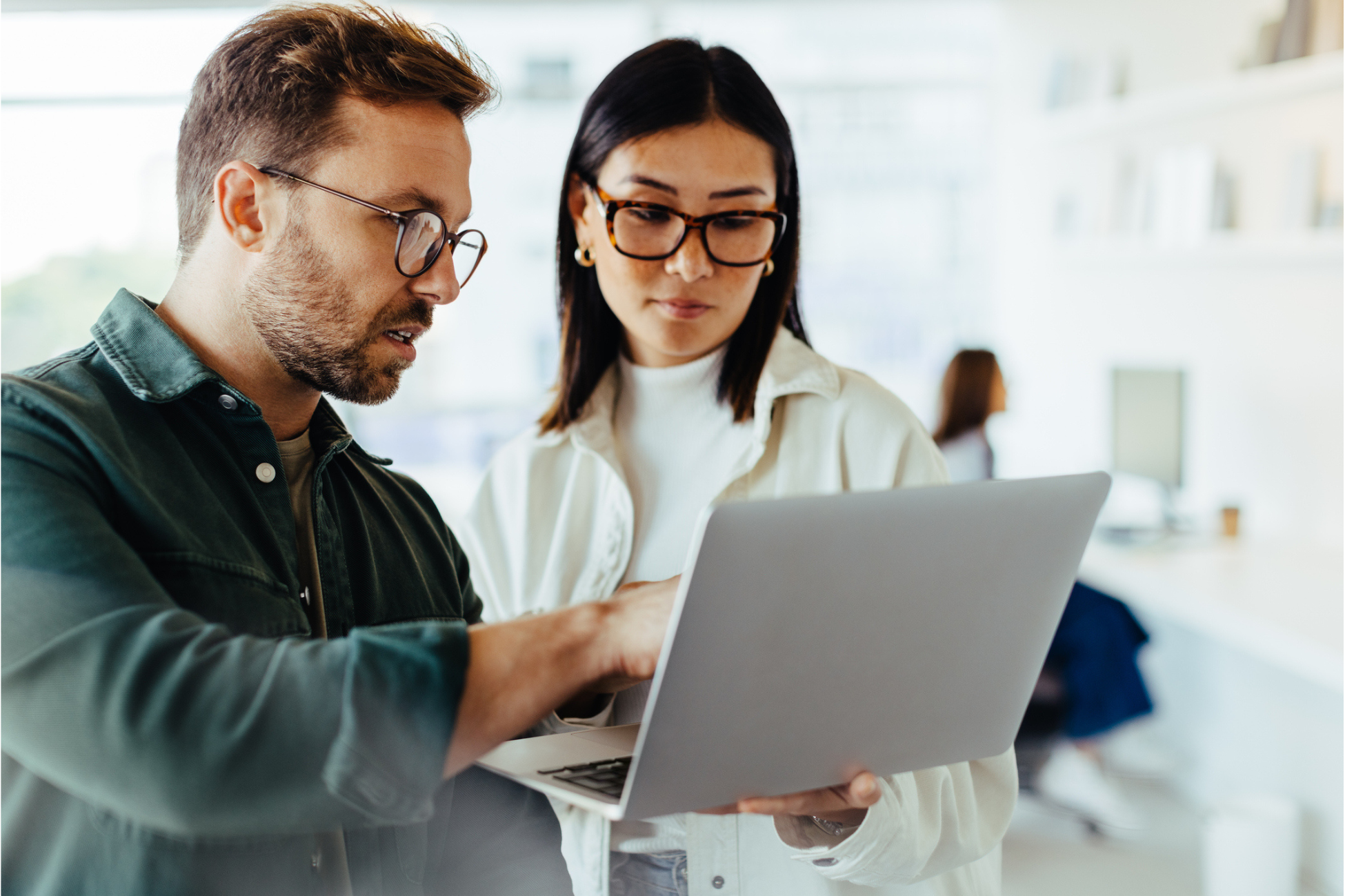 Two retail planners reviewing sales data on a laptop to improve merchandise financial planning processes, including sales forecasting, open-to-buy decisions, and data-driven inventory and allocation strategies.
