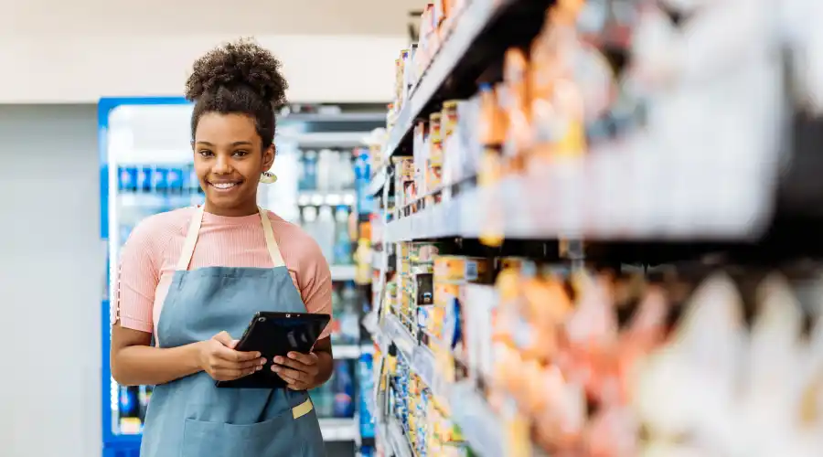 Retail employee using a digital tablet to manage supply chain decisions