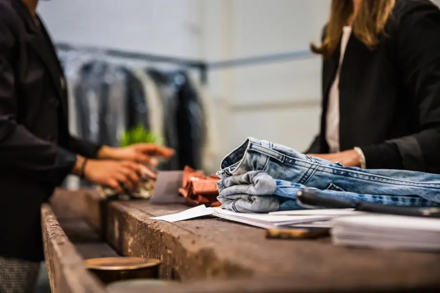 Sales associate assisting customer during apparel return, illustrating reverse logistics and customer experience challenges in retail returns 2026.